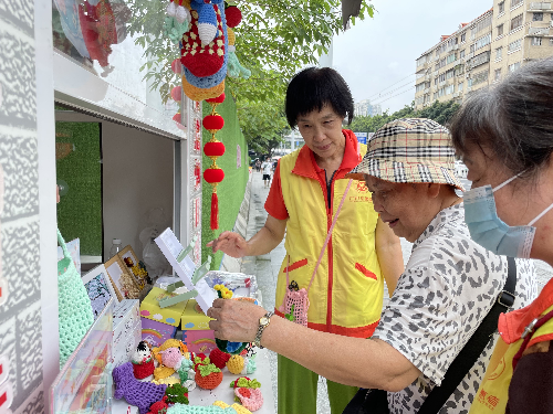 （图：社区居民挑选义卖品）.png