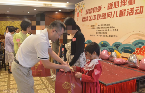 图：与会领导为儿童赠送慰问品.png