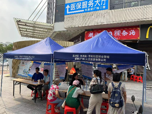 图2：就业驿站工作人员向求职者介绍就业政策.jpg