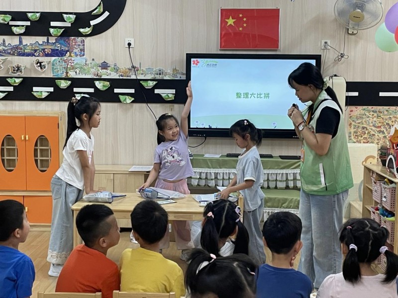 图：“整理大比拼”环节，率先完成的小朋友高高举起了手.jpg