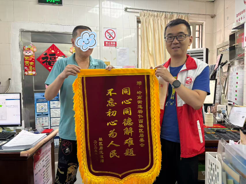 图：居民送锦旗答谢社区工作人员.jpg