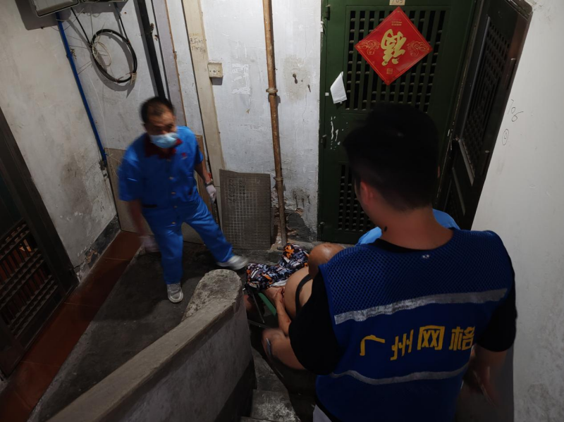 （图：网格员与医护人员合力将老人用担架从9楼抬下） .png