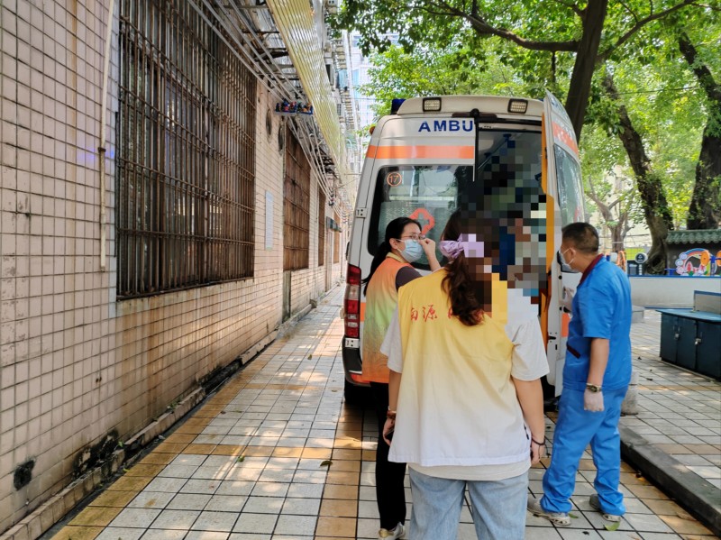 （图：网格员协助医护人员安全送上救护车）.jpg