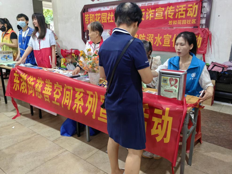 （图：志愿者向居民讲解慈善相关政策）.png