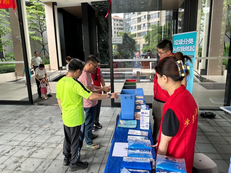 图：工作人员指引居民完成“分类投桶”小游戏.jpg